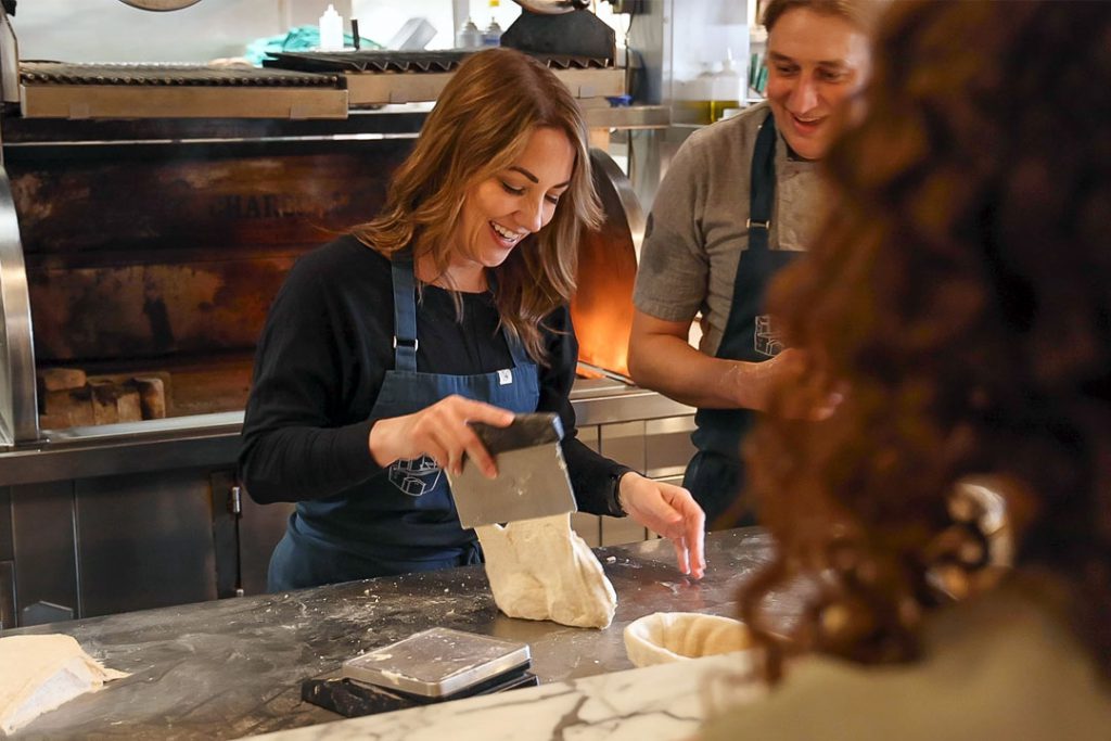 Woman working bread dough in Elora Mill kitchen